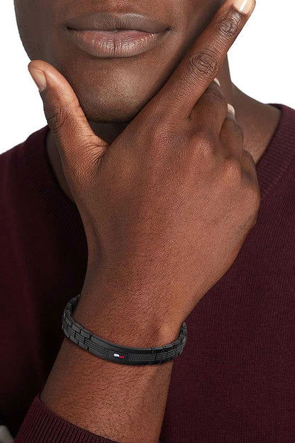 Gliederarmband von Tommy Hilfiger på handleden, svart med struktur och röda accenter