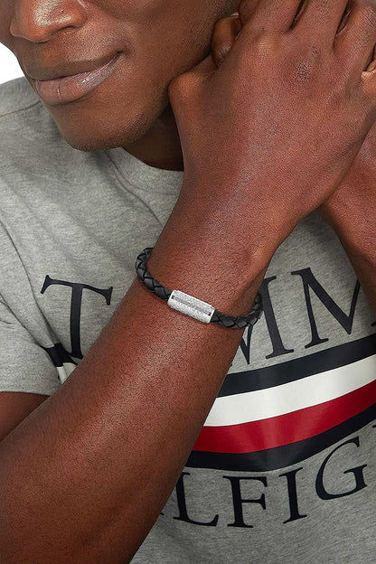 "Svart flätat läderarmband med silverfärgat spänne."