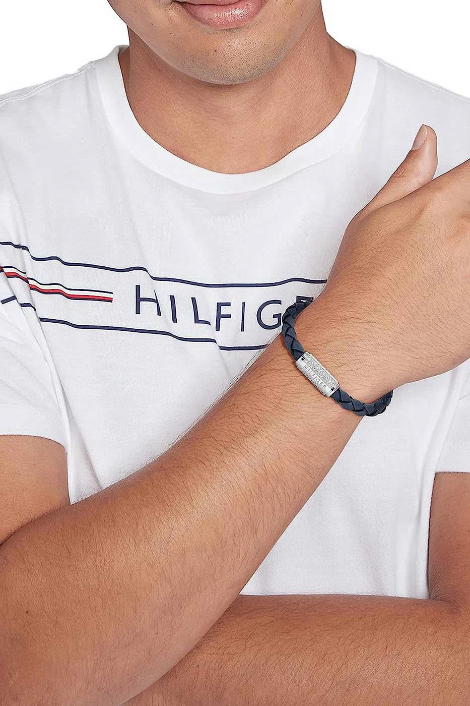 "Mörkblått flätat läderarmband runt handleden med silverfärgat spänne med Hilfiger-logotyp"