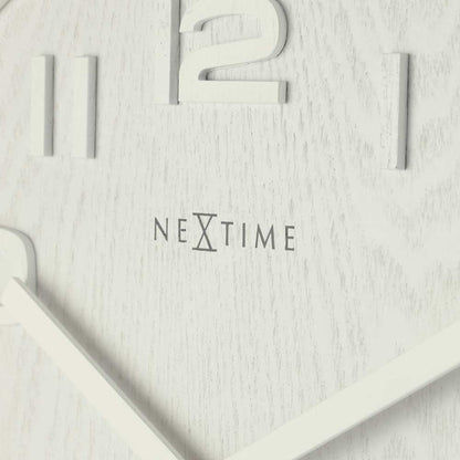 Detaljerad vy av väggklocka med NEXTIME-logotyp, visare och siffror