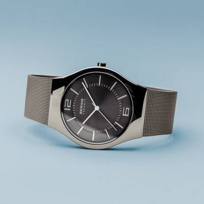 Herrenarmbanduhr seitlich mit dunkelgrauem Zifferblatt und silbernem Milanaise-Armband