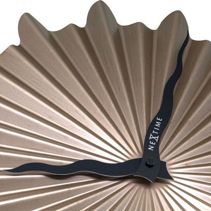 Väggklocka i guldfärgad snäckdesign, närbild av den svarta visarbasen