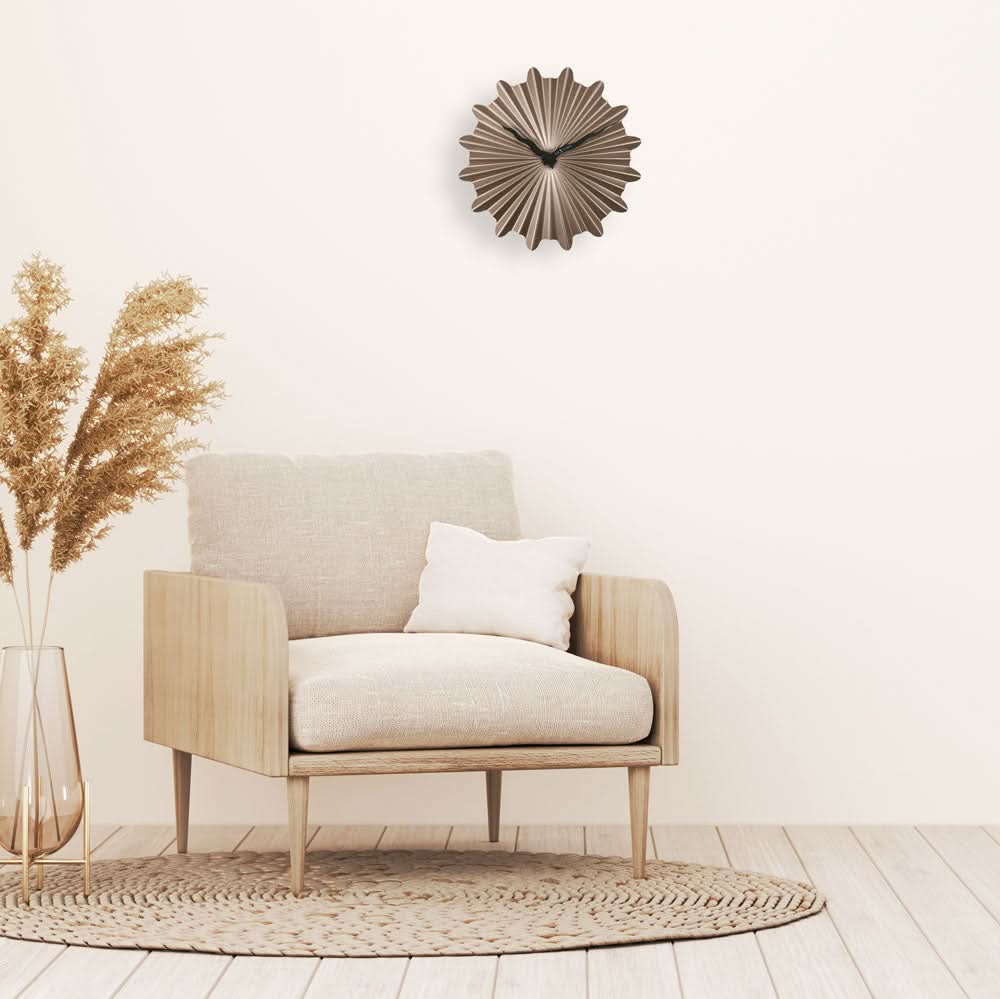 Väggklocka i snäckskalsdesign, guldfärgad metalloptik, från längre avstånd