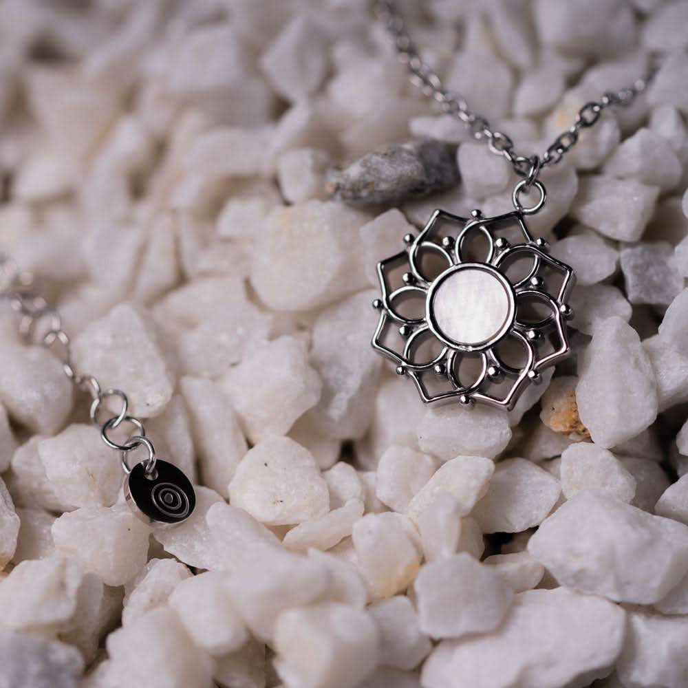 "Halsband med runt pärlemorhänge i solhjul-design, silverfärgad"