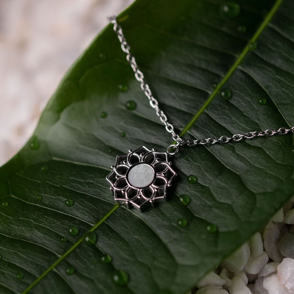 "Halsband med rund pärlemorhänge och solhjul-design på kedjan"