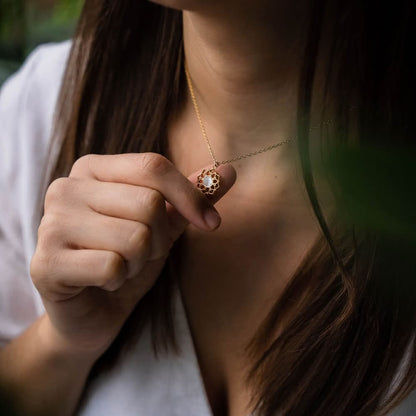Guldpläterat halsband med pärlemorhänge, blommig cirkelfattning