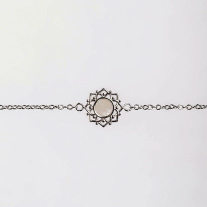 "Armband med silverfärgad länk och runt pärlemorhänge i ornamentram"