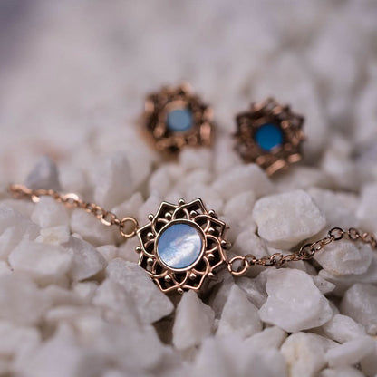 Armband med blå pärlemorcabochon i guldfärgad ornamentram, länkkedja