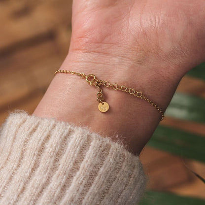 Fint armband med guldkedja och runt armbandslås på handleden