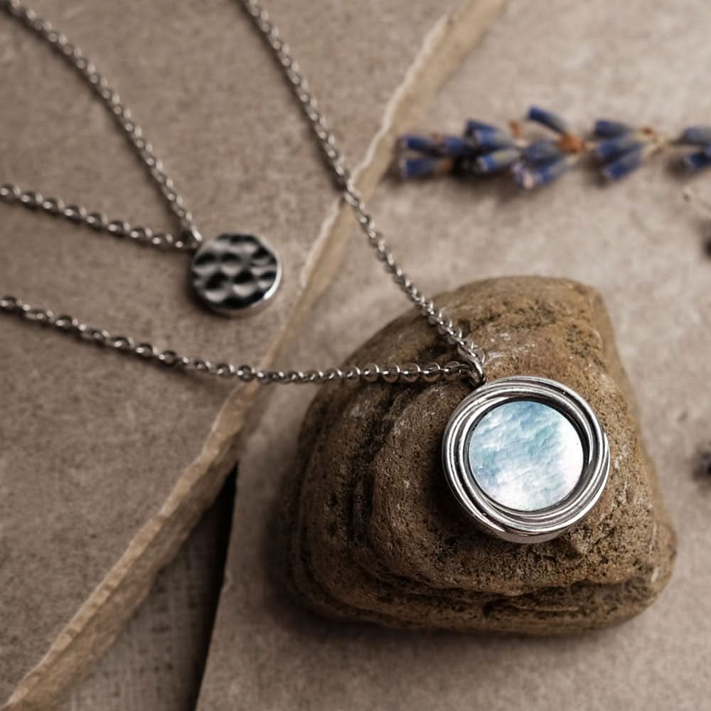 Halsband i sterlingsilver med rund pärlemordiamant och liten mönstrad berlock
