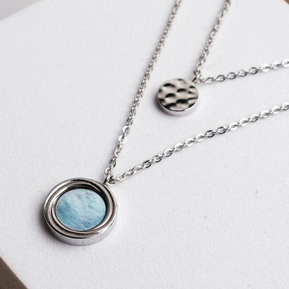 Halsband i sterlingsilver med rund pärlemordiamant och liten mönstrad berlock