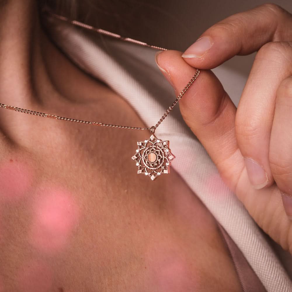 Halsband med guldfärgat kedja och runt hänge, närbild