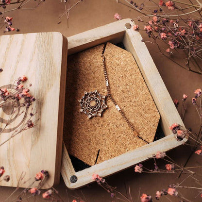 Halsband med guldfärgat kedja och runt hänge i ornamentdesign