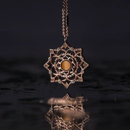 "Halsband med guldfärgat kedja och stort runt hänge med ornament"