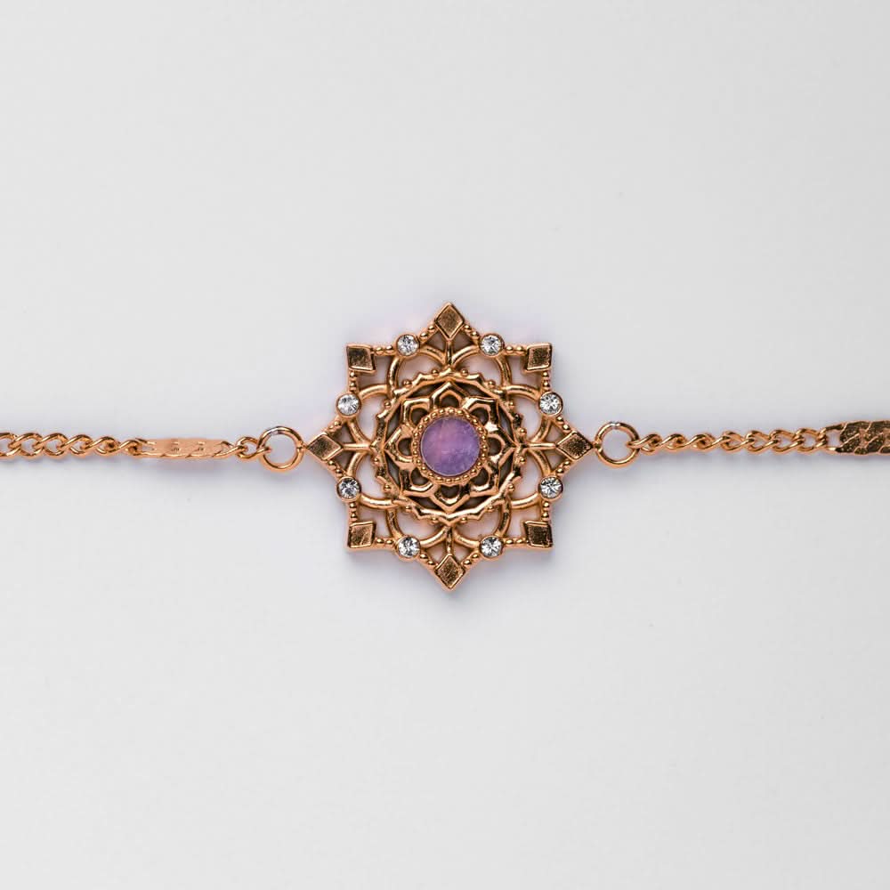 Armband med guldfärgad kedjelänk och snöflingeberlock med lila sten