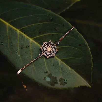 Guldpläterat armband med mandalainspirerat hänge på en tunn kedja