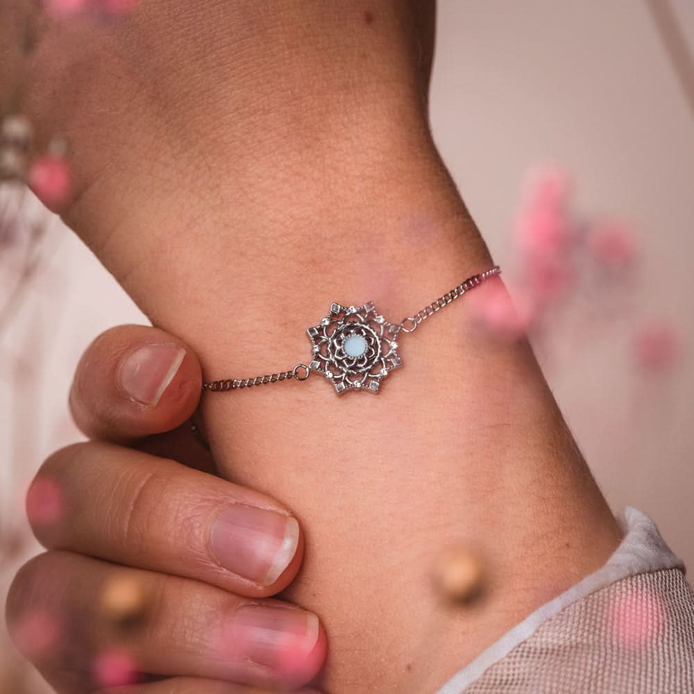 Armband på handleden med silverfärgad kedja och rund blå prydnadssten