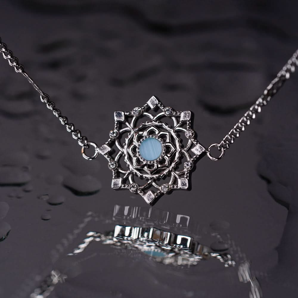 Armband med berlock i silverfärgad kedja, rund blå mittpunkt i ornament