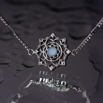 Armband med berlock i silverfärgad kedja, rund blå mittpunkt i ornament