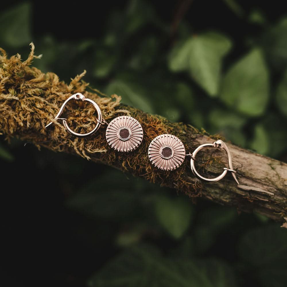 Ett par örhängen med runda hängen med strass och en liten mittring, guldfärgade