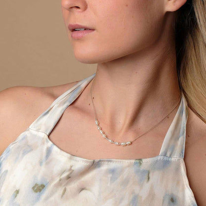 Halsband med fina pärlor och silverdetaljer, bärs runt halsen