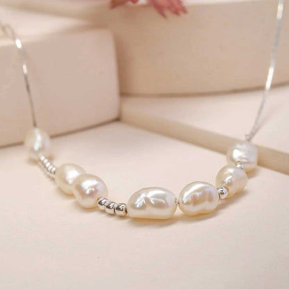 Pärlhalsband med ovala pärlor och silverdistanser, synligt lås