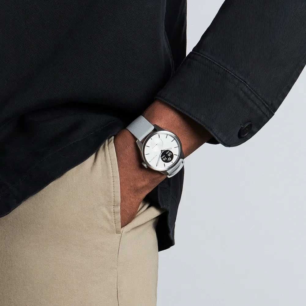 Smartklocka på handleden, grått armband och vit urtavla under skjorta