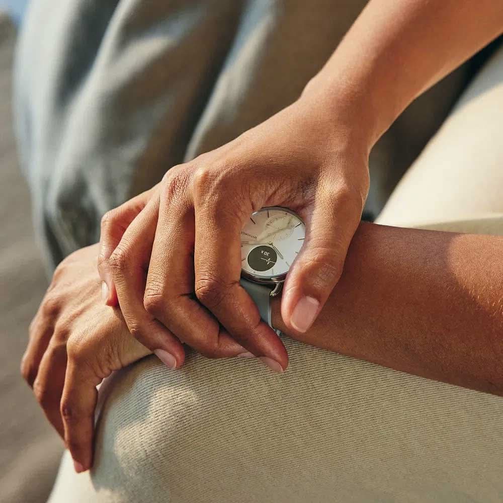 Withings smartklocka på handleden med grått armband och temp-visning på svart display