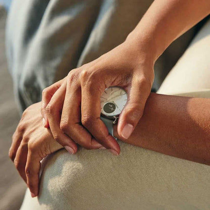 Withings smartklocka på handleden med grått armband och temp-visning på svart display