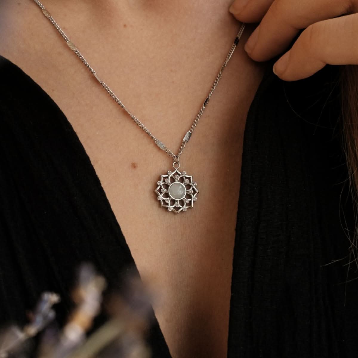 "Silket halsband med rund månstenshänge i blomsterfattning"