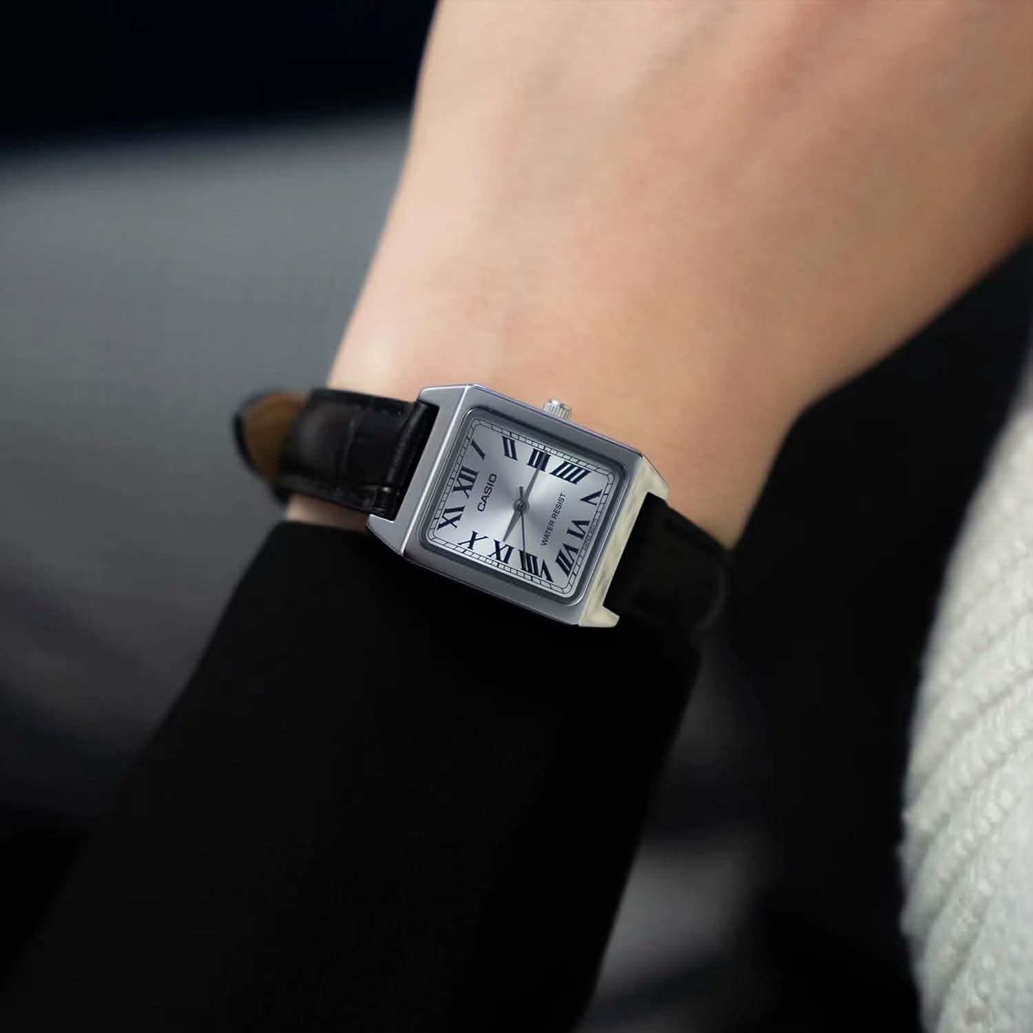 Casio damklocka på handleden med mörkblått läderarmband och analog urtavla.