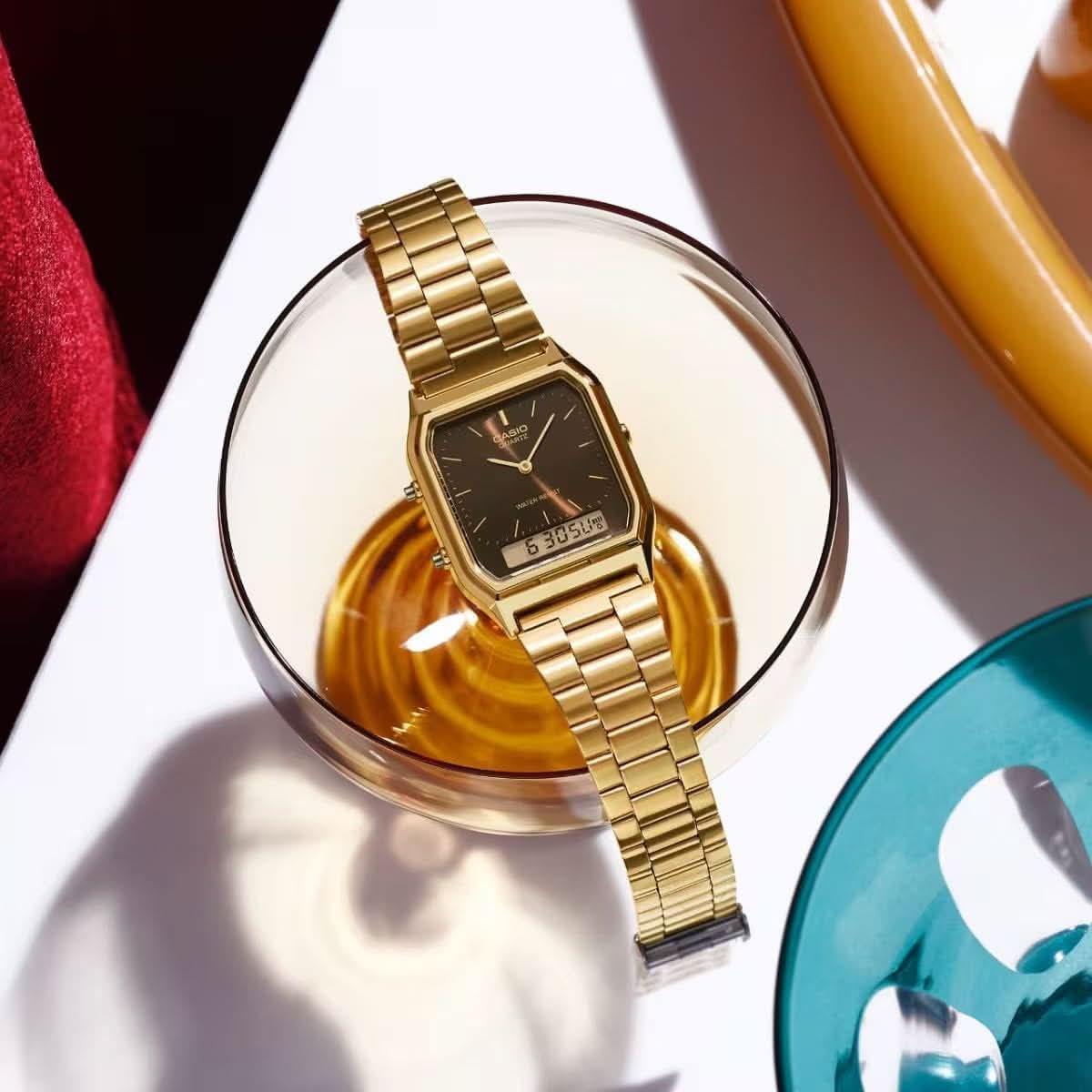 Guld färgad retroklocka på handleden med metallarmband och svart urtavla