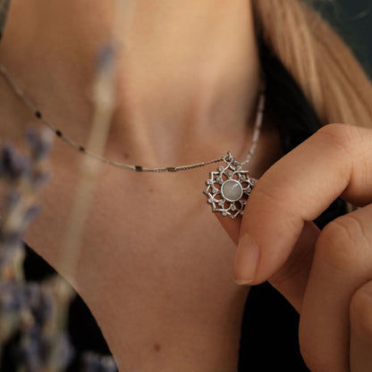 "Silket halsband med månstenshänge och konstnärligt blomsterinfattning"
