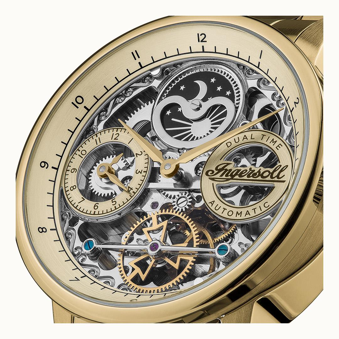 Goldfarbene Armbanduhr im Nahblick: skelletiertes Zifferblatt mit Mondphase und Dual Time