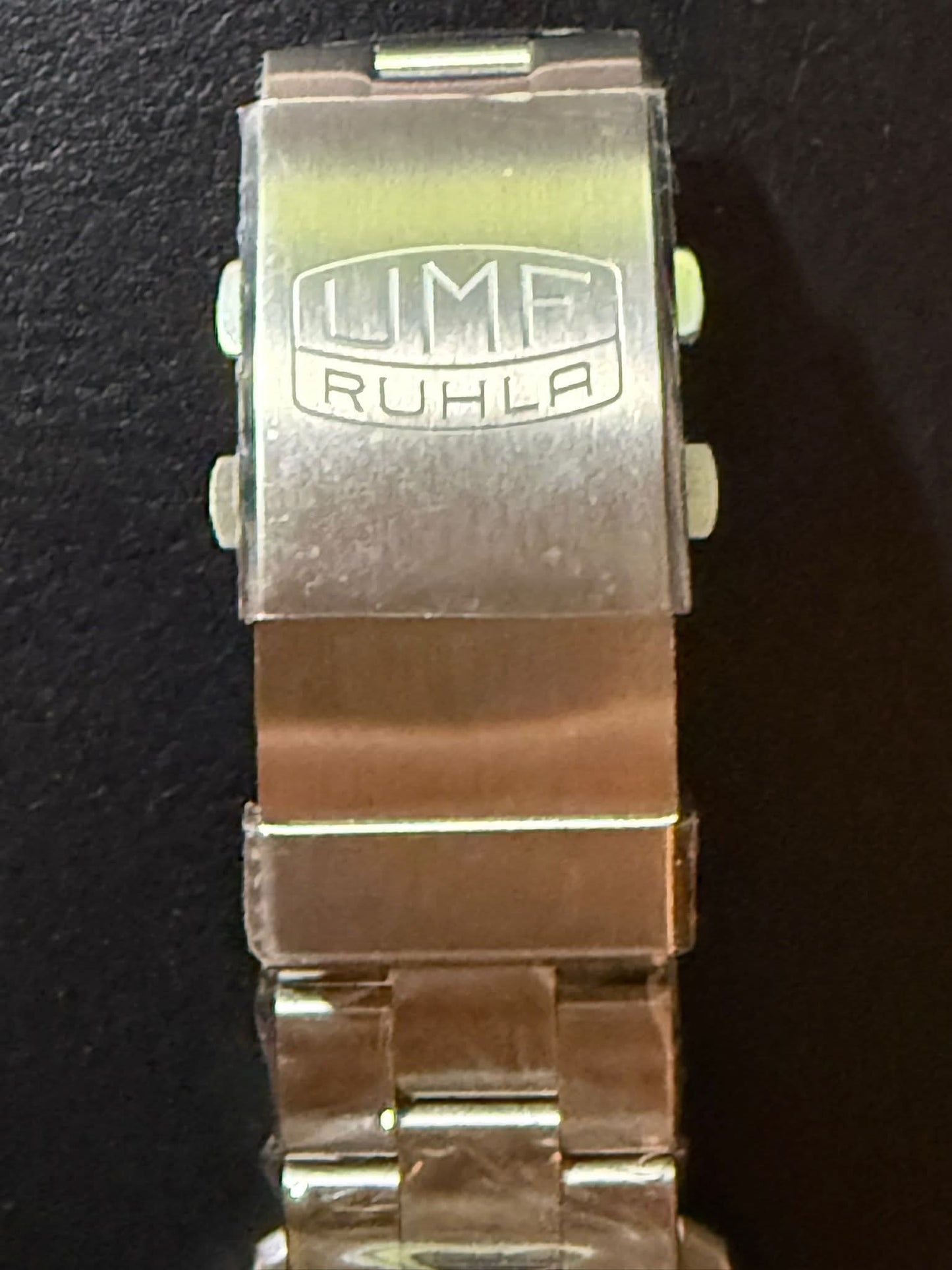Stängning med UMF RUHLA-prägling och brunt läderarmband