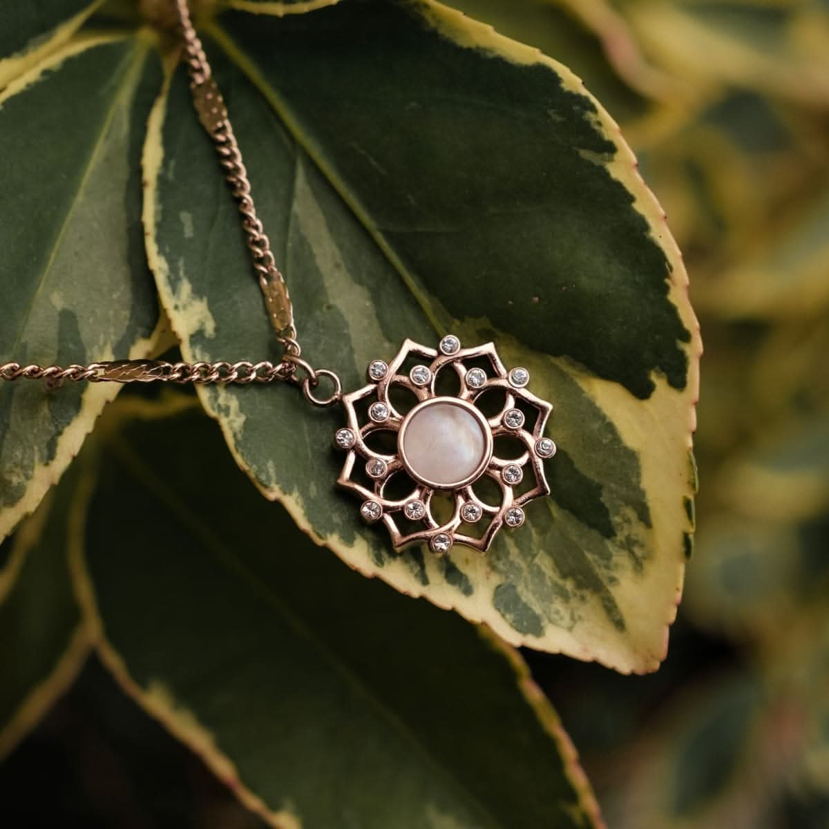"Halsband med rund ljus sten i rosett-hänge och roséfärgat band"