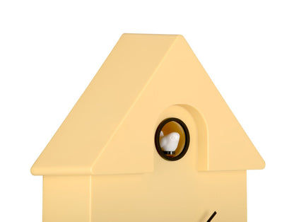 Väggklocka i fågelholksdesign, närbild av runt fönster på gult hölje