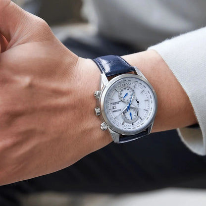 Herrarmbandsur på handleden: blått läderarmband, silverfärgat hölje, vit urtavla