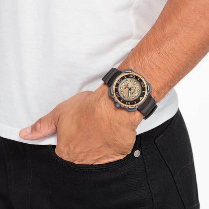Herrarmbandsur på handleden med svart armband och ljus, grönaktig urtavla