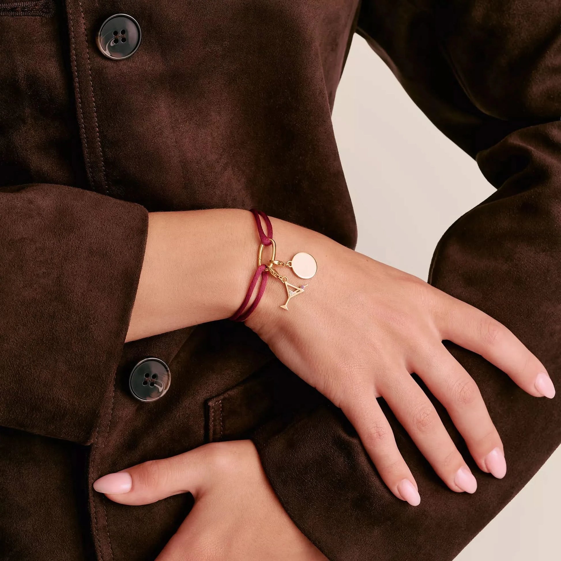 Rött textilarmband runt handleden med guldfärgat Connect-element