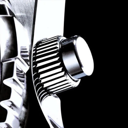 Metalltryckknappar och räfflad struktur på infattningen, silverfärgat hölje