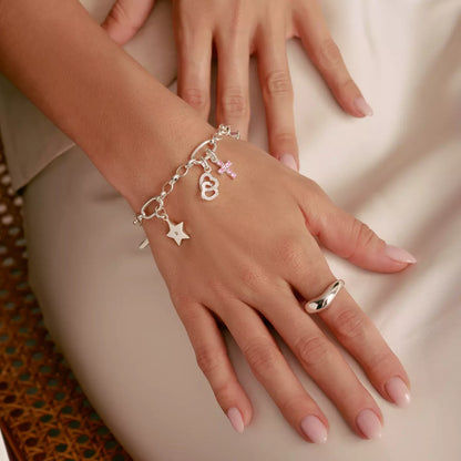 Berlockarmband med silverfärgade berlocker, inklusive rött hjärta och stjärna