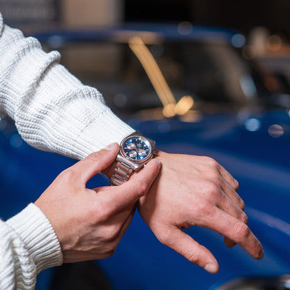 Armbandsur på handleden med blå urtavla och silverfärgat rostfritt stålarmband