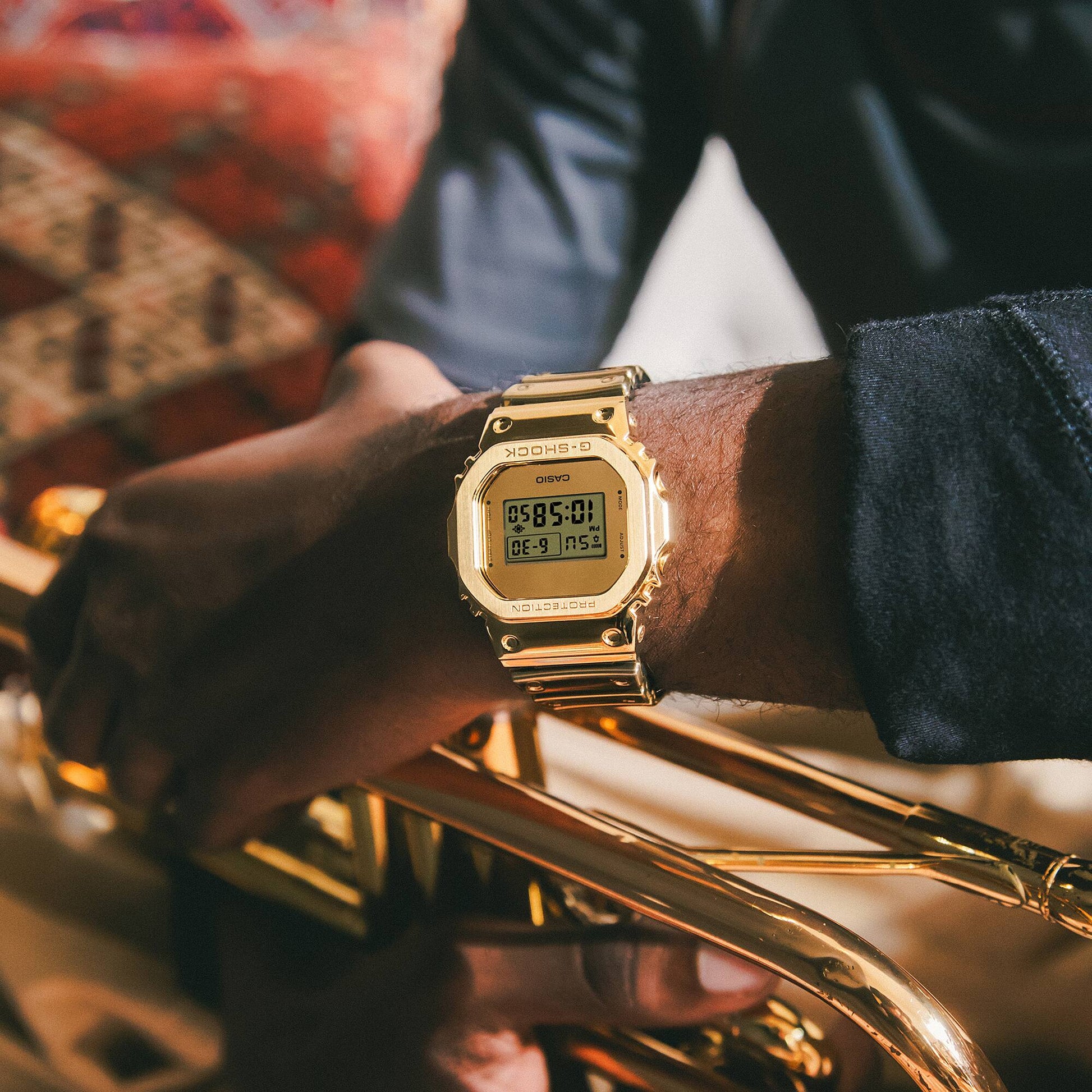 Casio G-Shock Armbanduhr am Handgelenk, goldfarbener Edelstahl und digitales Display