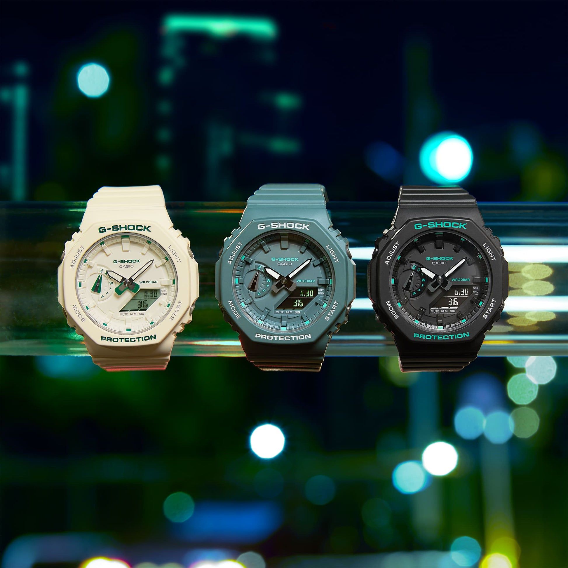 Drei Casio G-Shock Armbanduhren nebeneinander: weiß, blaugrün und schwarz mit grünen Details.