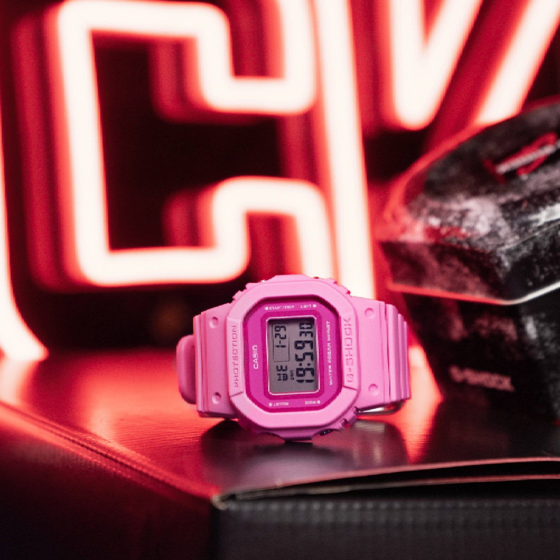 Casio G‑SHOCK Damenuhr auf Unterlage, pinkes Resinarmband mit digitalem Display