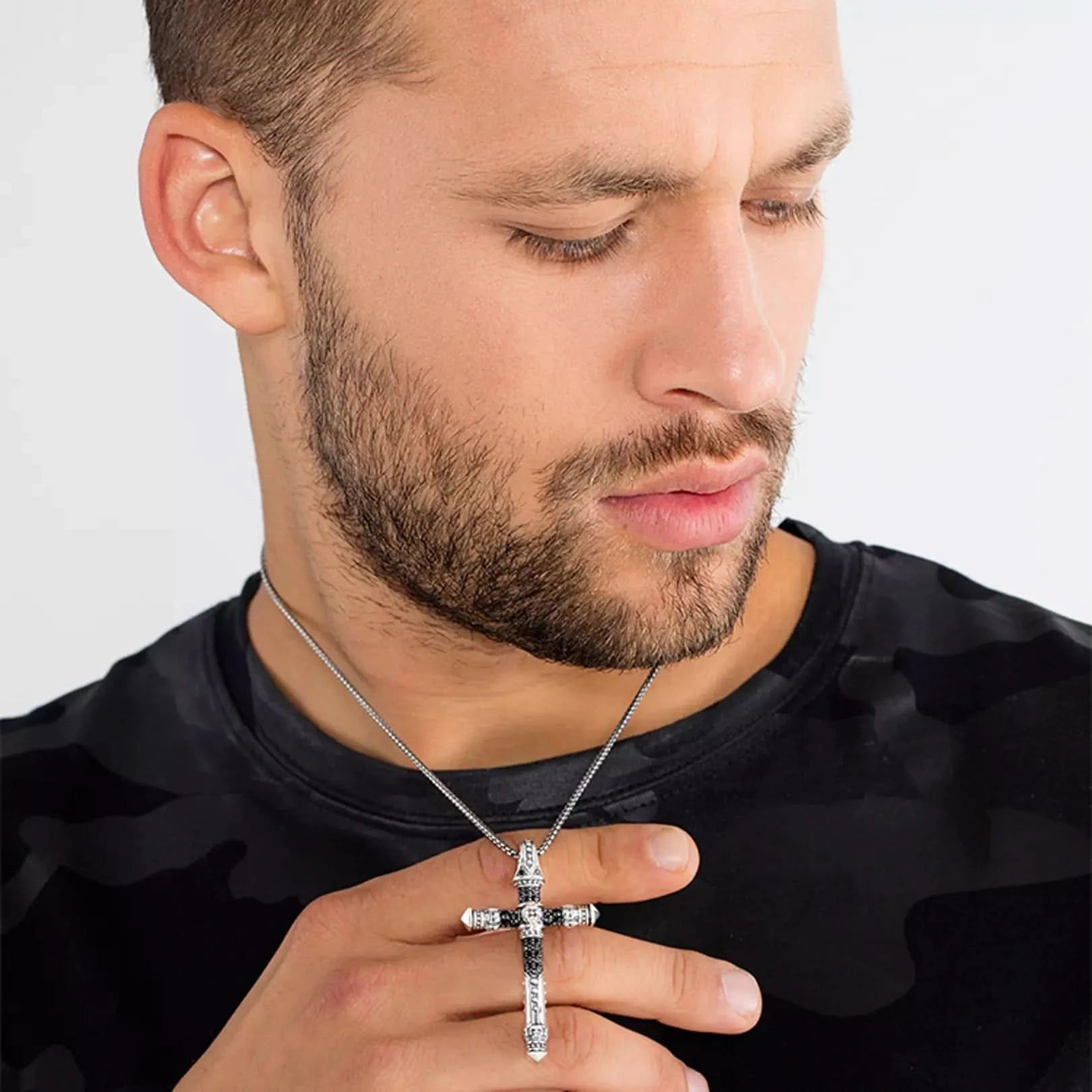Svart unisex-halsband med hänge, avlångt korsmotiv, vid halsen
