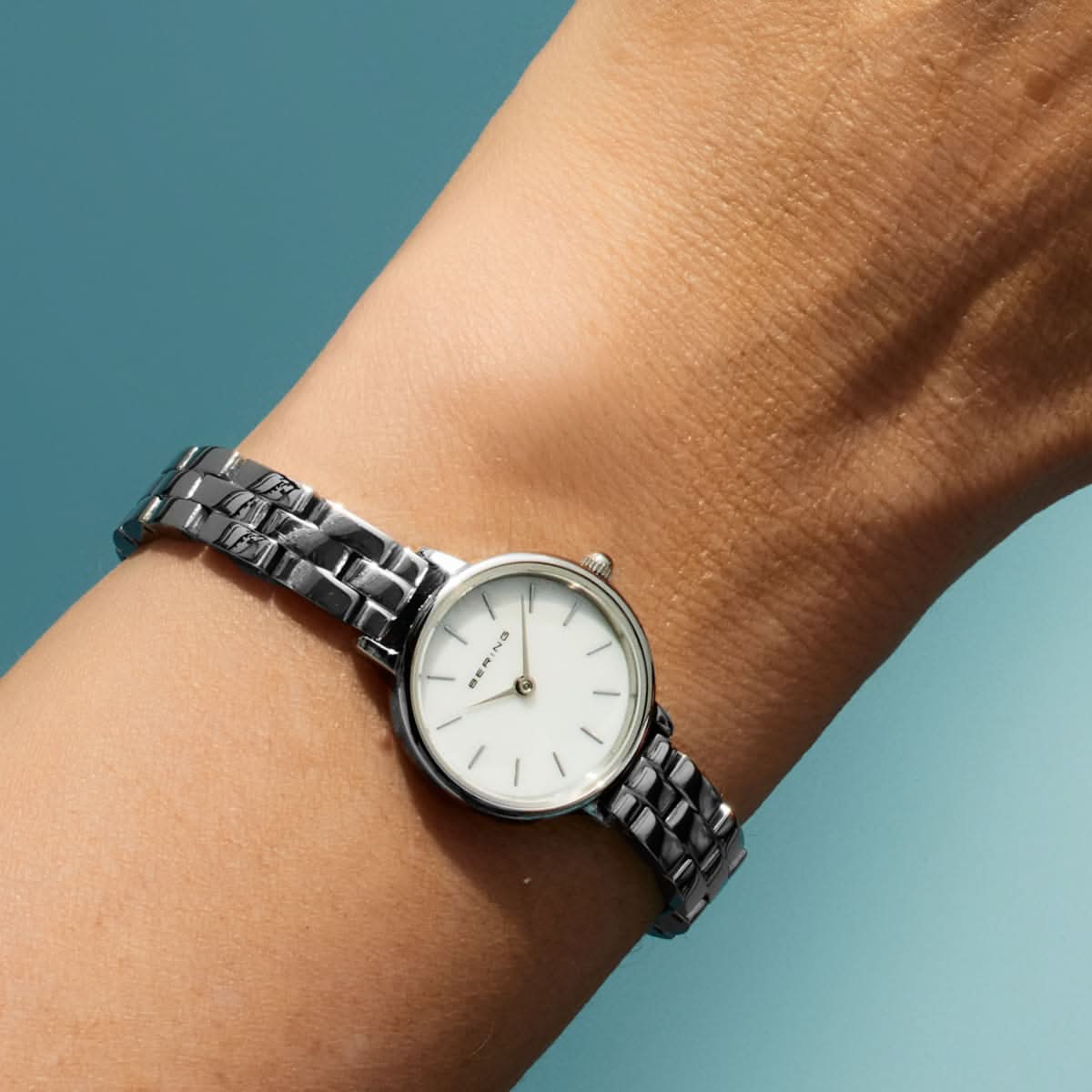 Bering damklocka på handleden med silverfärgat metallarmband och ljus urtavla