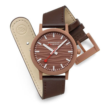 Mondaine Unisex-klocka med brunt läderband; brun urtavla, röda accenter, justerbart spänne.