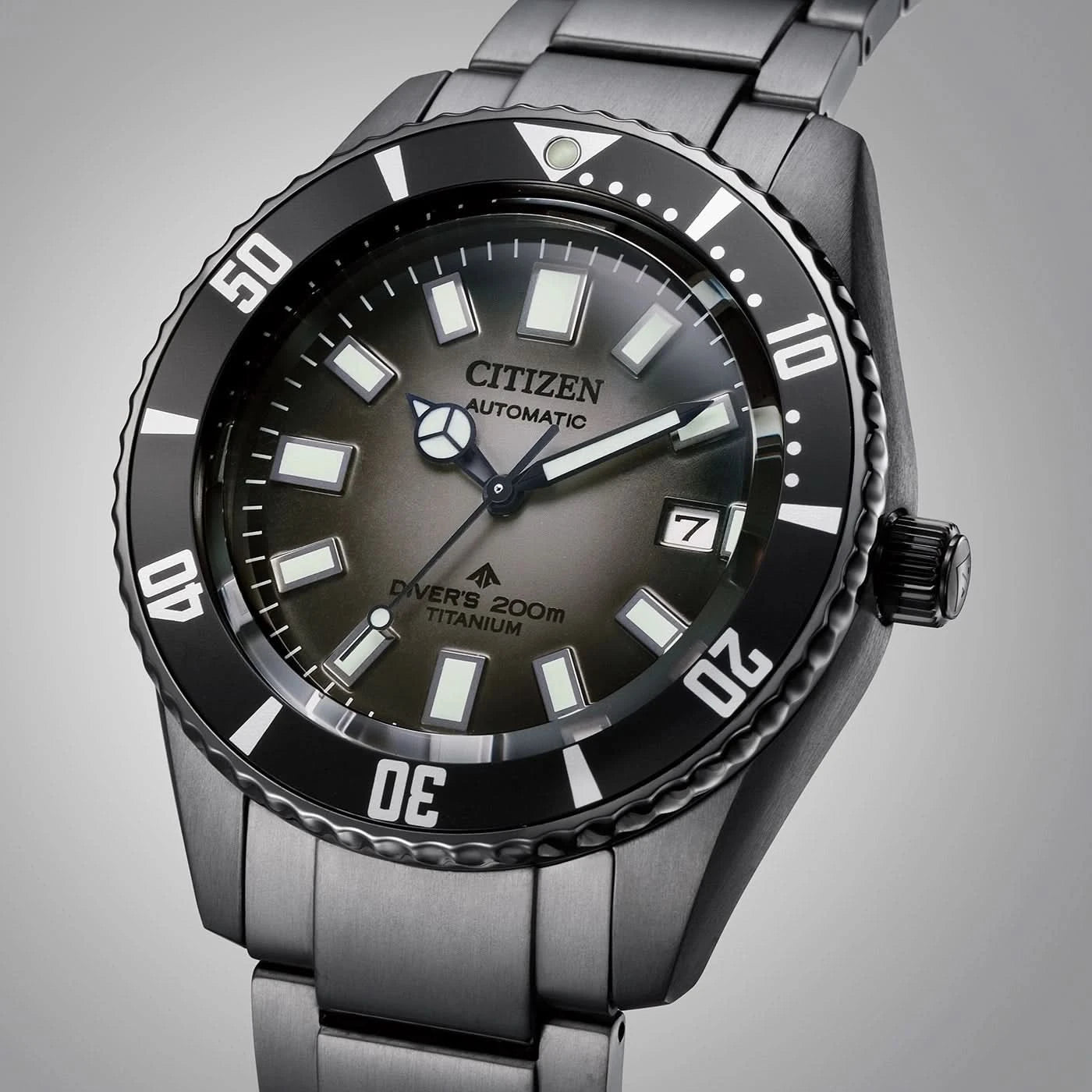 Mörk dykarklocka med svart infattning, självlysande index och metallarmband